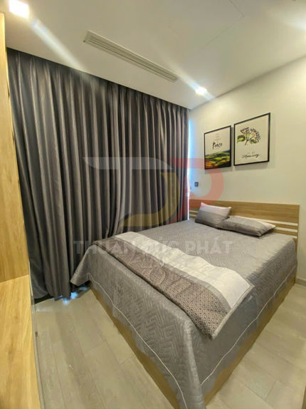 Phòng ngủ nhỏ với giường đôi bọc chăn ga màu xám, rèm cửa tối màu và tranh treo tường hiện đại