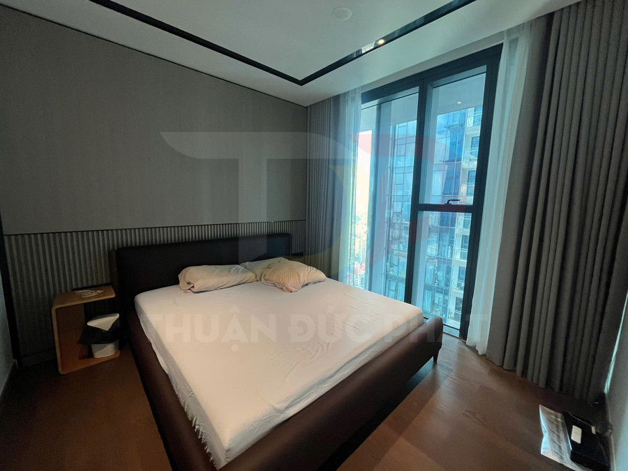 Phòng ngủ chung cư hiện đại với giường đôi bọc da cạnh cửa sổ kính lớn nhìn ra thành phố