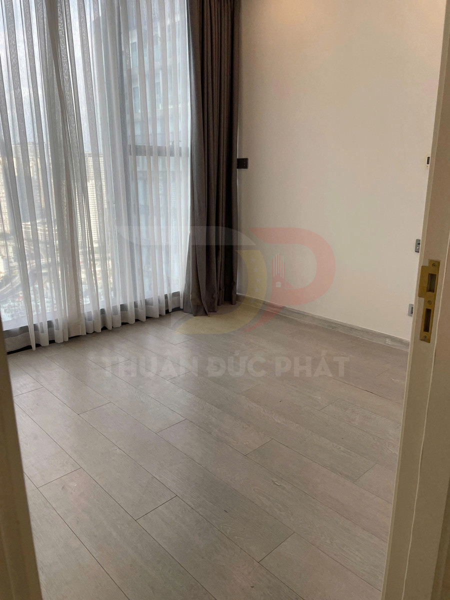 Sàn gỗ công nghiệp màu sáng trong phòng trống với rèm cửa sổ lớn tone nâu xám