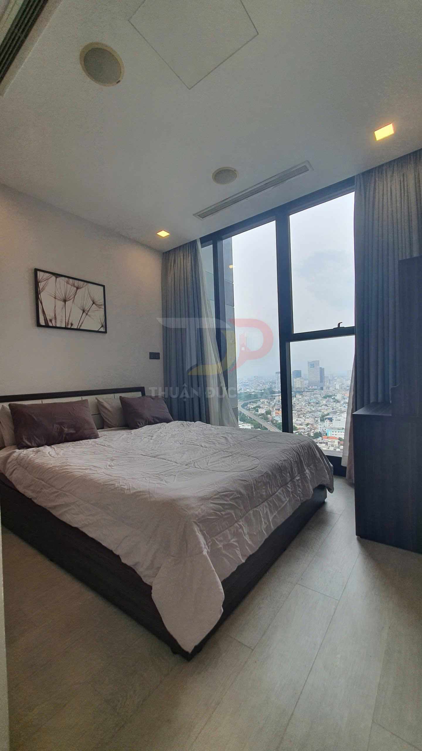 Phòng ngủ hiện đại với giường đôi ga trắng, cửa sổ kính lớn nhìn ra thành phố