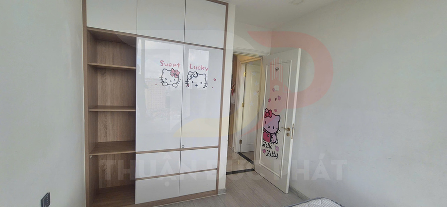 Tủ quần áo gỗ cửa trắng dán hình Hello Kitty trong phòng ngủ bé gái sáng sủa
