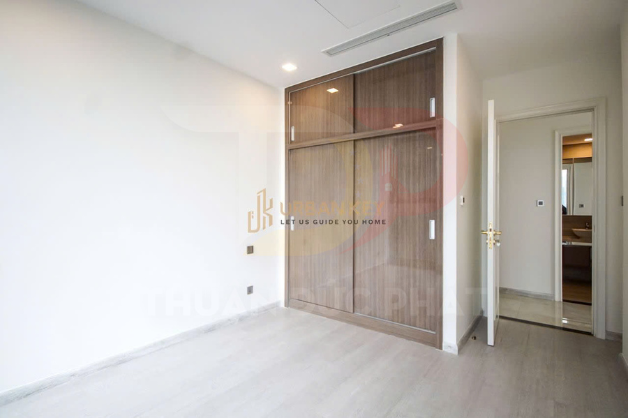 Phòng ngủ trống với tủ quần áo cửa lùa gỗ hiện đại cạnh cửa ra vào và sàn màu sáng
