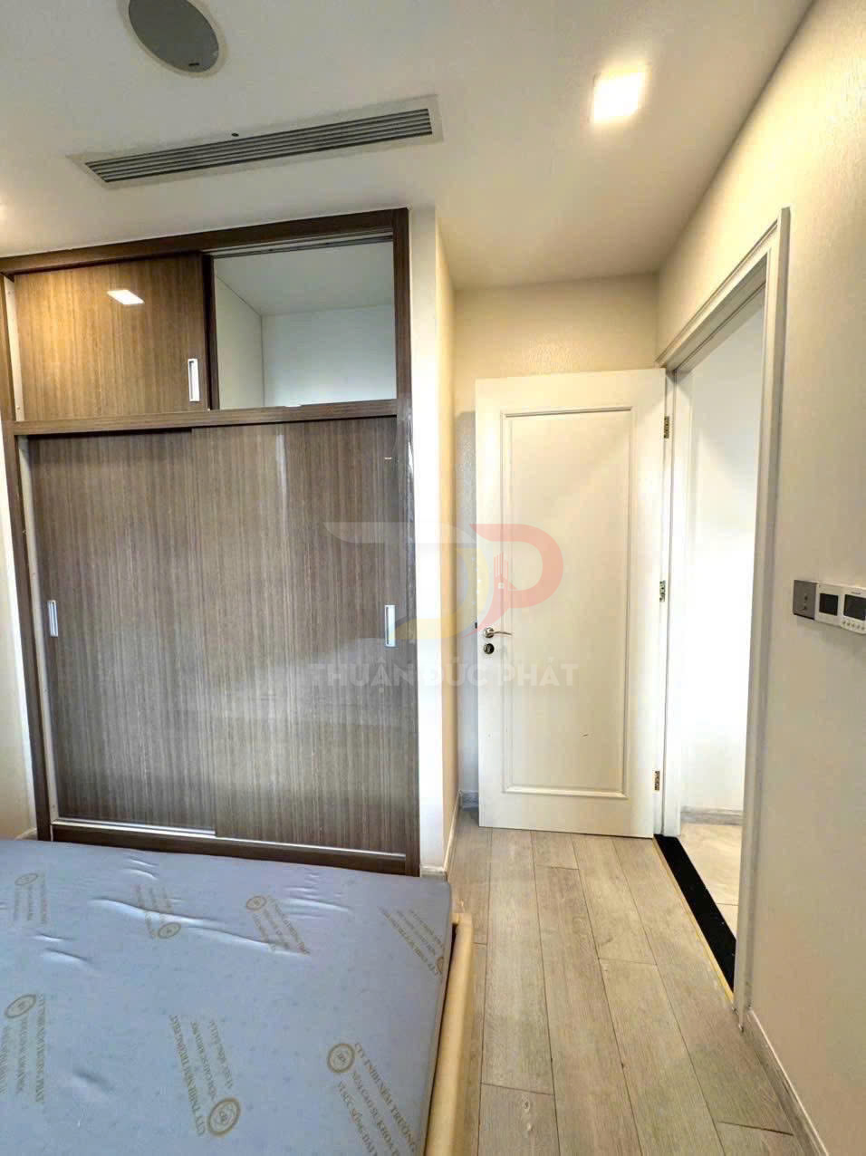 Tủ quần áo gỗ cửa lùa trong phòng ngủ nhỏ hiện đại với giường và sàn gỗ sáng màu