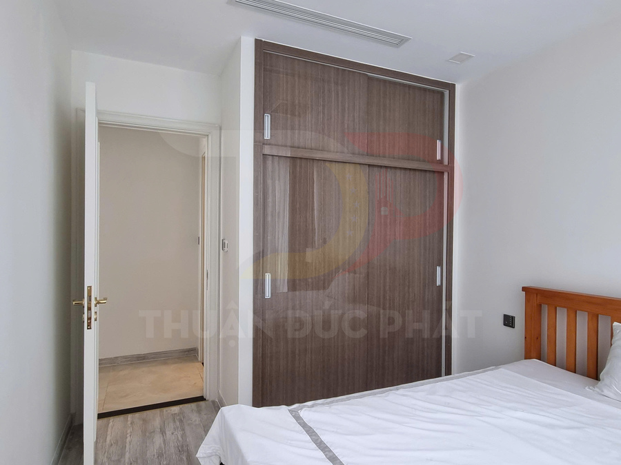 Tủ quần áo gỗ cửa lùa trong phòng ngủ nhỏ hiện đại cạnh giường gỗ và cửa ra vào mở