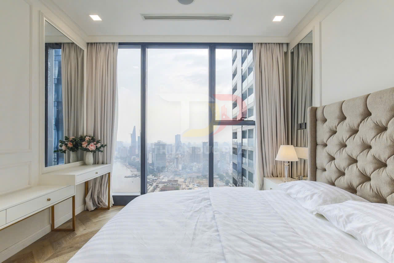 Phòng ngủ chung cư cao cấp với giường bọc nệm và cửa kính lớn nhìn ra toàn cảnh thành phố