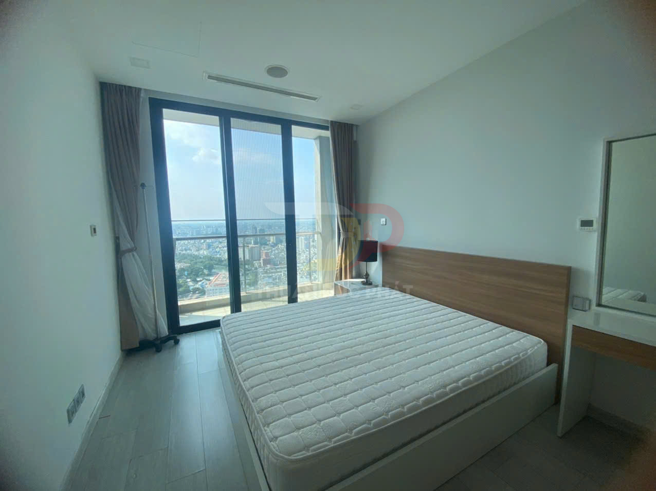 Phòng ngủ chung cư hiện đại với giường nệm lớn cạnh cửa kính toàn cảnh view thành phố