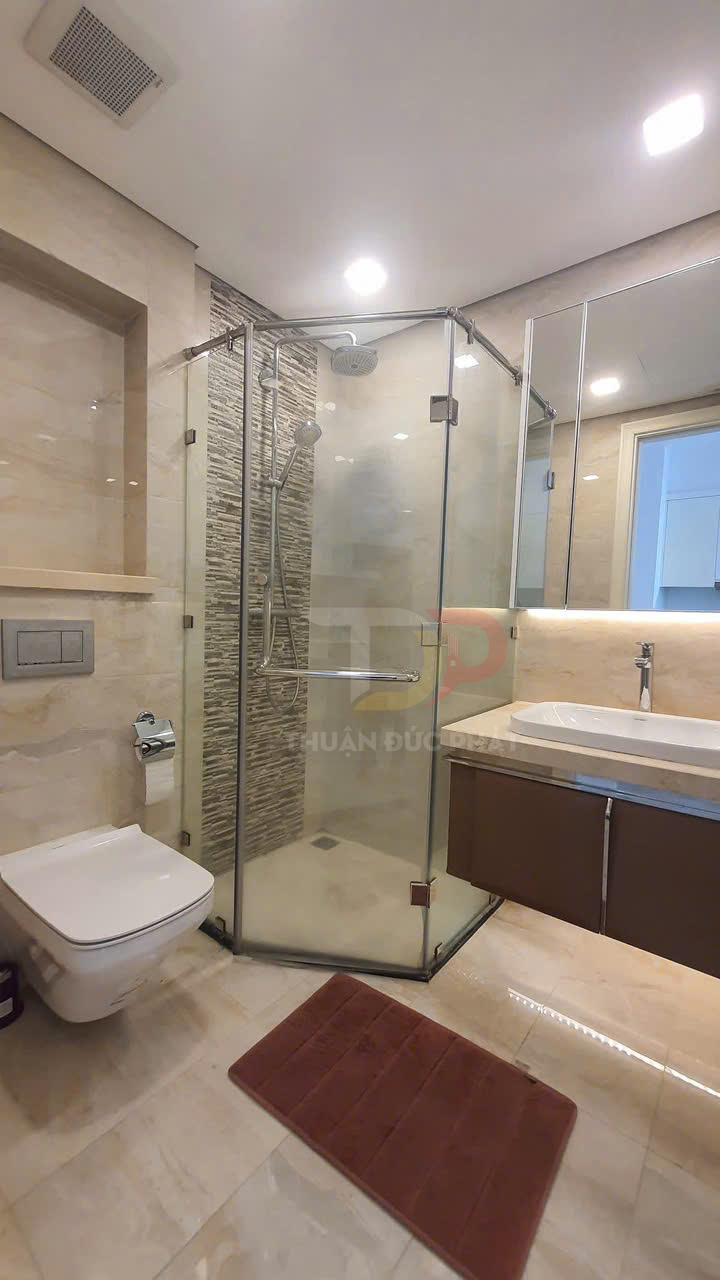 Phòng tắm hiện đại với buồng tắm kính, vòi sen, bồn cầu treo tường và lavabo đá sang trọng