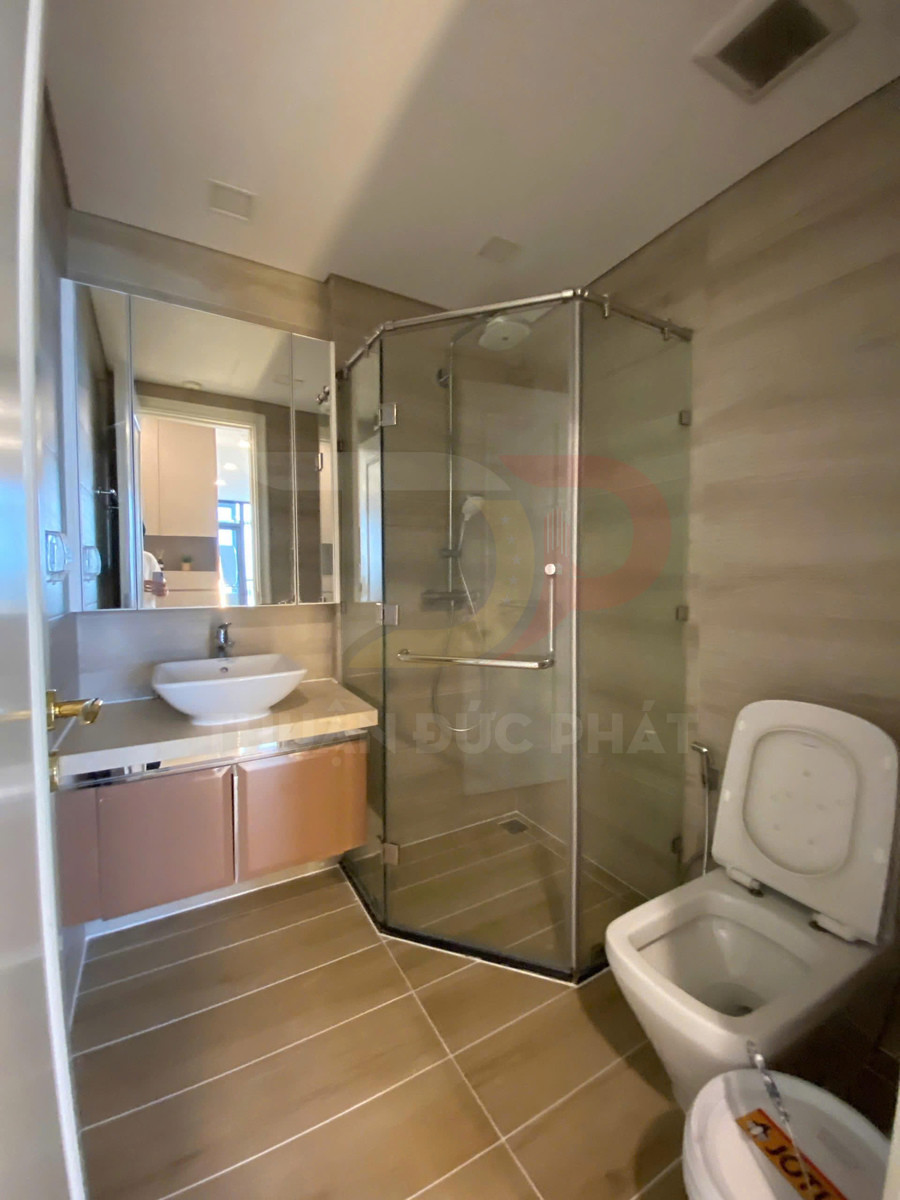 Phòng tắm hiện đại với buồng tắm kính, bồn rửa mặt đặt bàn và bồn cầu sứ trắng