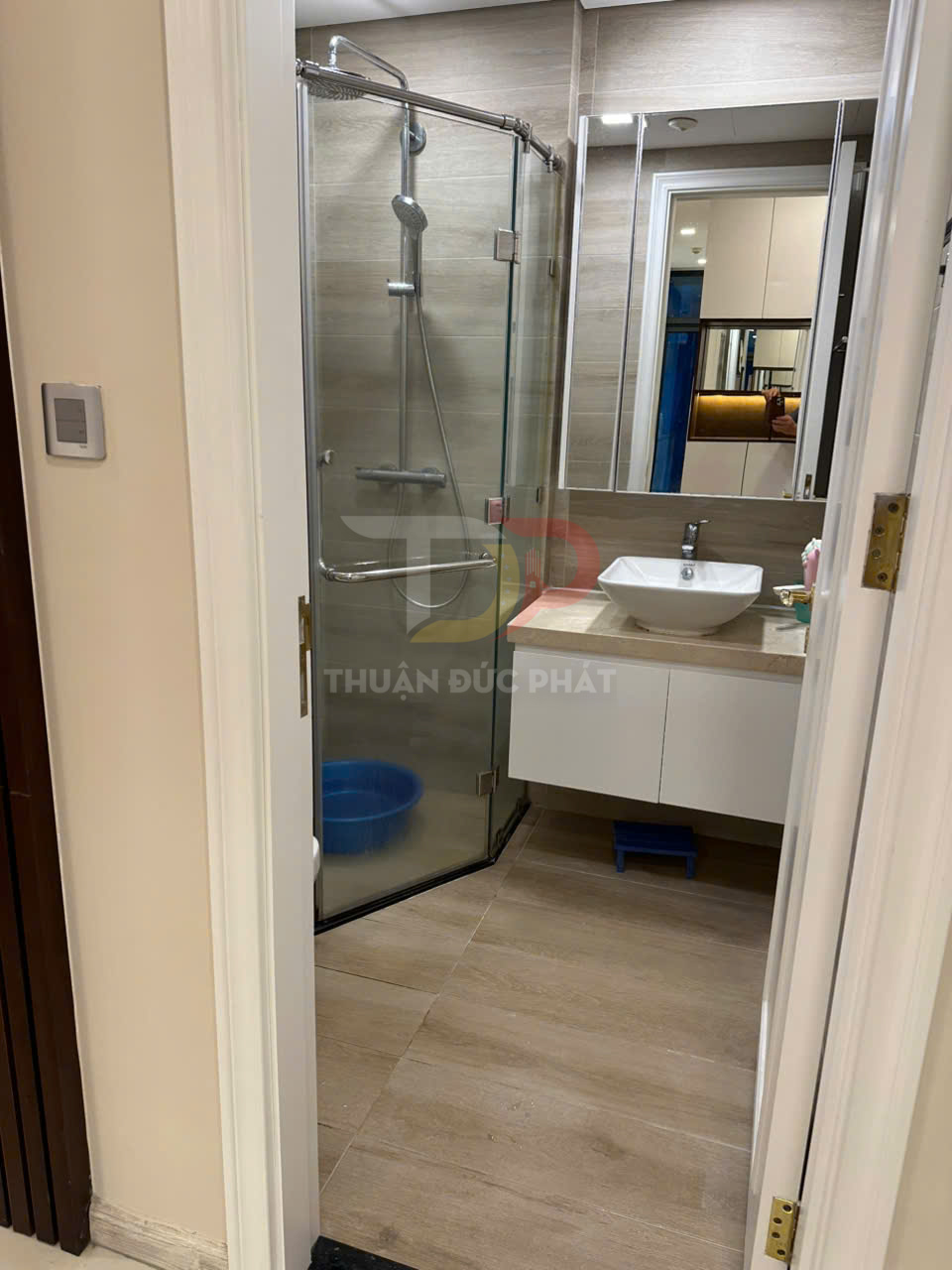 Phòng tắm hiện đại với vách kính tắm đứng, vòi sen inox và tủ lavabo treo tường trắng