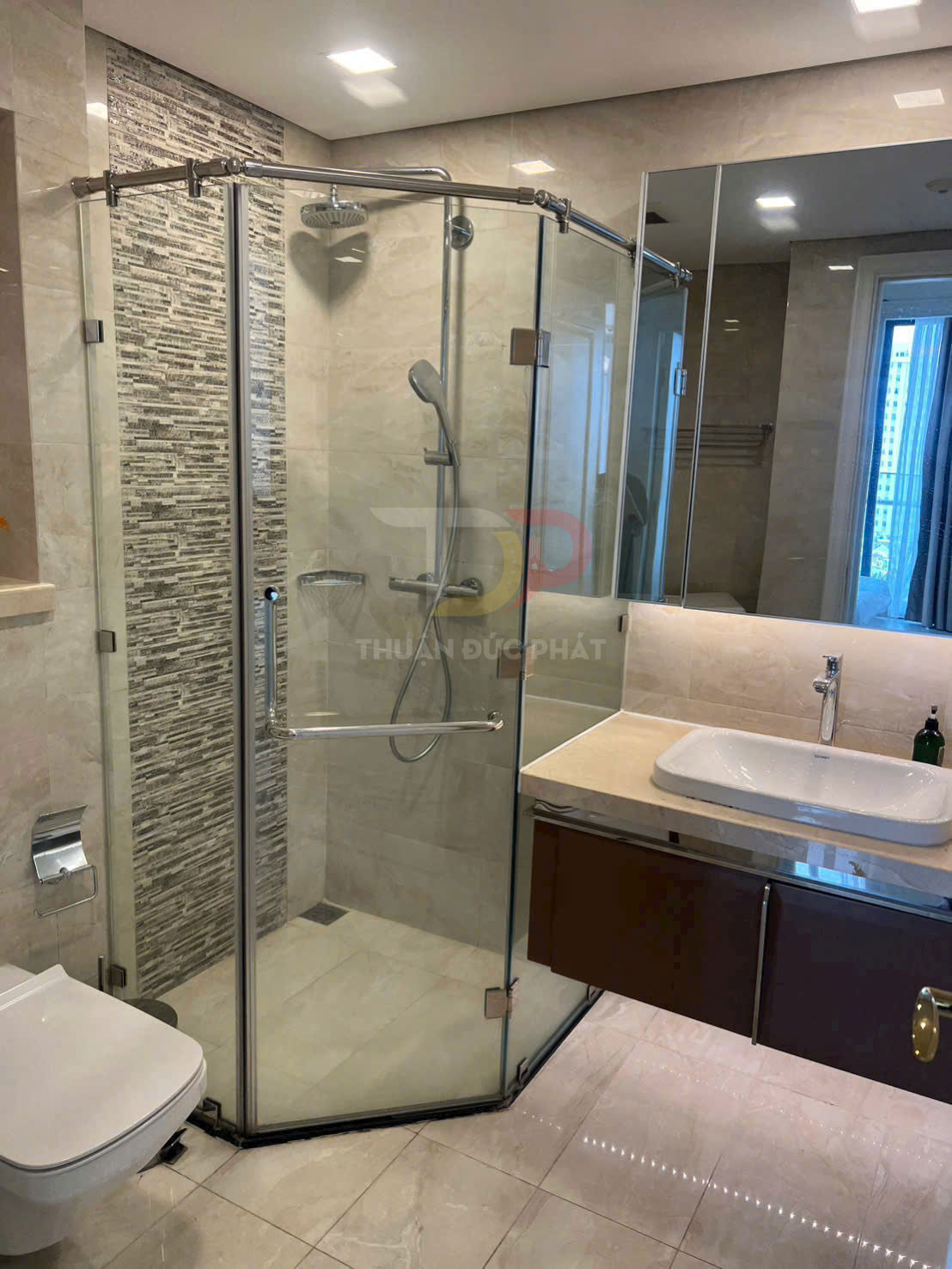 Phòng tắm hiện đại với vách kính tắm đứng góc, vòi sen inox và lavabo mặt đá sang trọng