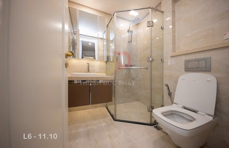 Phòng tắm hiện đại với bồn cầu, buồng tắm kính đứng và lavabo tủ gỗ sang trọng