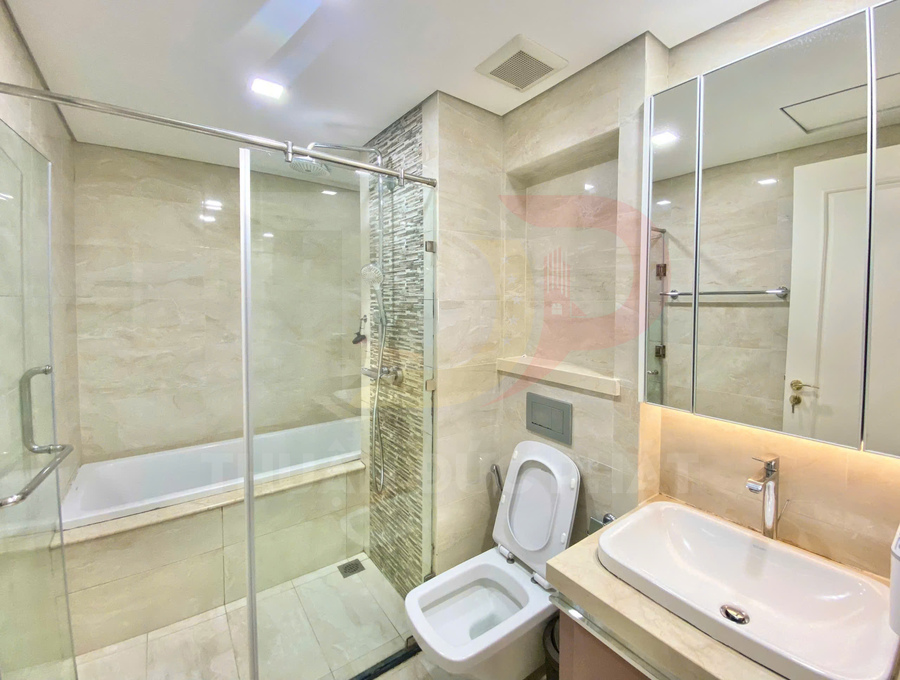 Phòng tắm hiện đại với buồng tắm kính, bồn tắm, bồn cầu và lavabo mặt đá sáng màu
