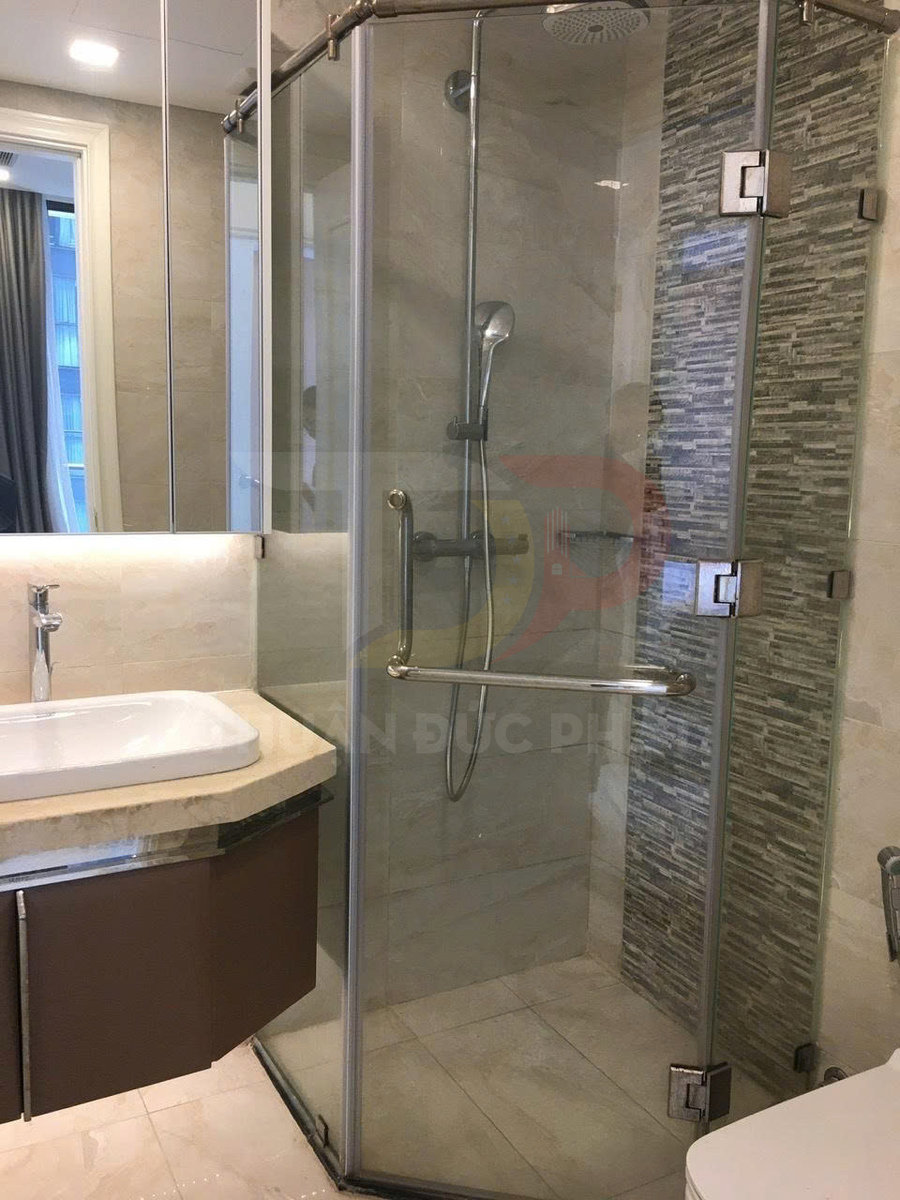 Phòng tắm hiện đại với vách kính tắm đứng, vòi sen tay và bồn rửa mặt đá sang trọng