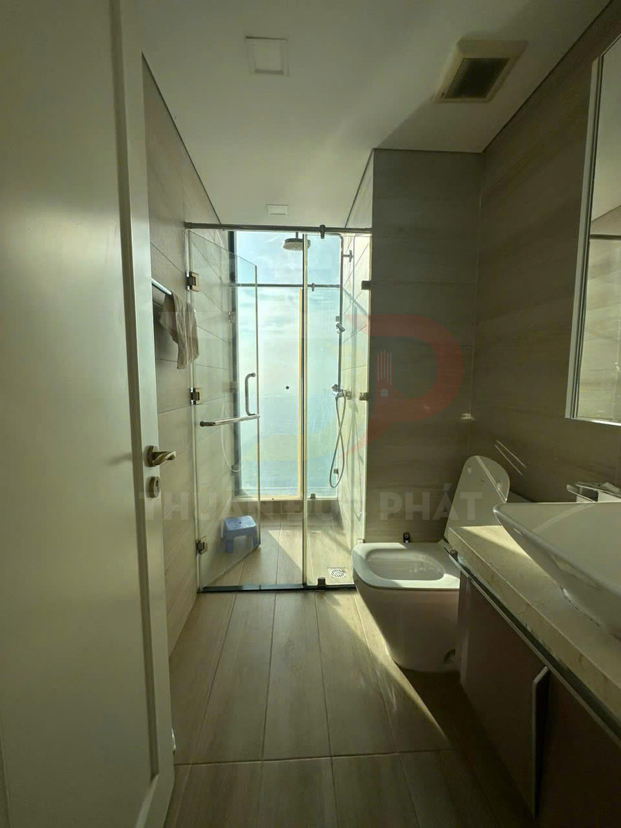 Phòng tắm hiện đại với buồng tắm kính, vòi sen trần, bồn cầu và lavabo đặt trên tủ gỗ