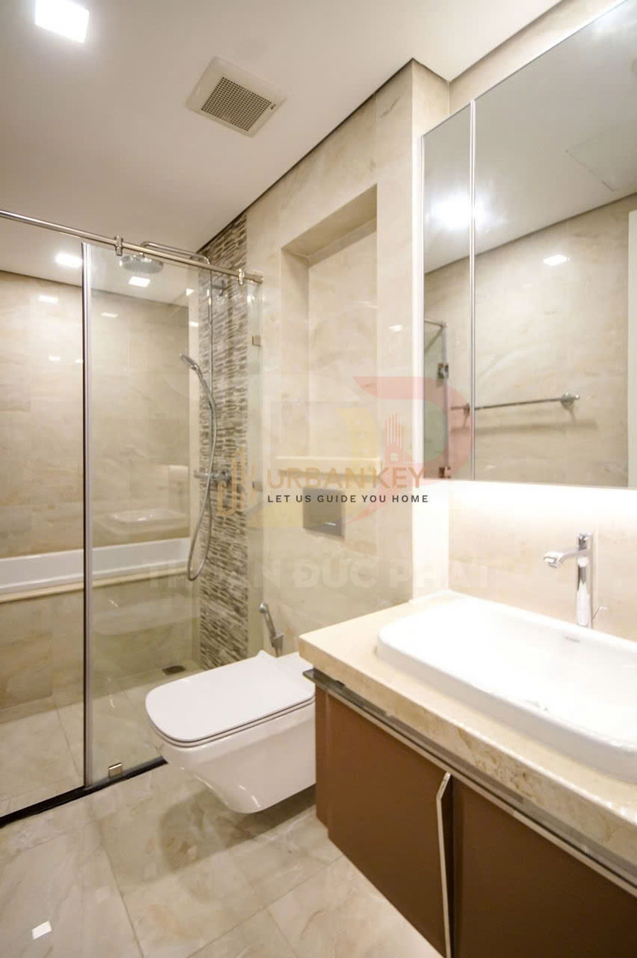 Phòng tắm hiện đại với bồn rửa mặt, bồn cầu treo tường và buồng tắm kính có vòi sen đứng