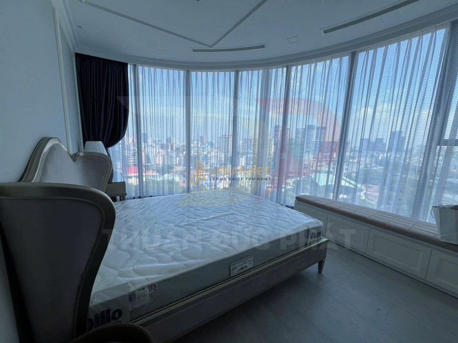 Phòng ngủ hiện đại với giường đôi cạnh cửa kính cong toàn cảnh nhìn ra thành phố