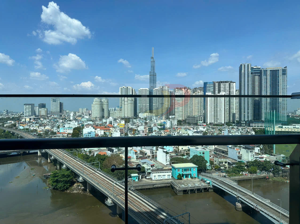 View thành phố với tòa nhà Landmark 81 và các chung cư cao tầng nhìn từ ban công qua sông và đường ray tàu