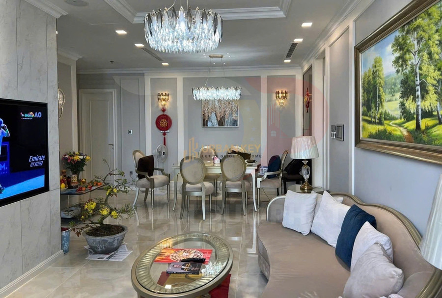 Phòng khách căn hộ cao cấp với sofa, bàn kính, đèn chùm pha lê và bàn ăn sang trọng