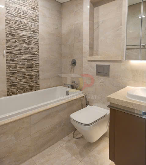 Phòng tắm hiện đại với bồn tắm nằm, bồn cầu treo tường và lavabo đá màu be sang trọng