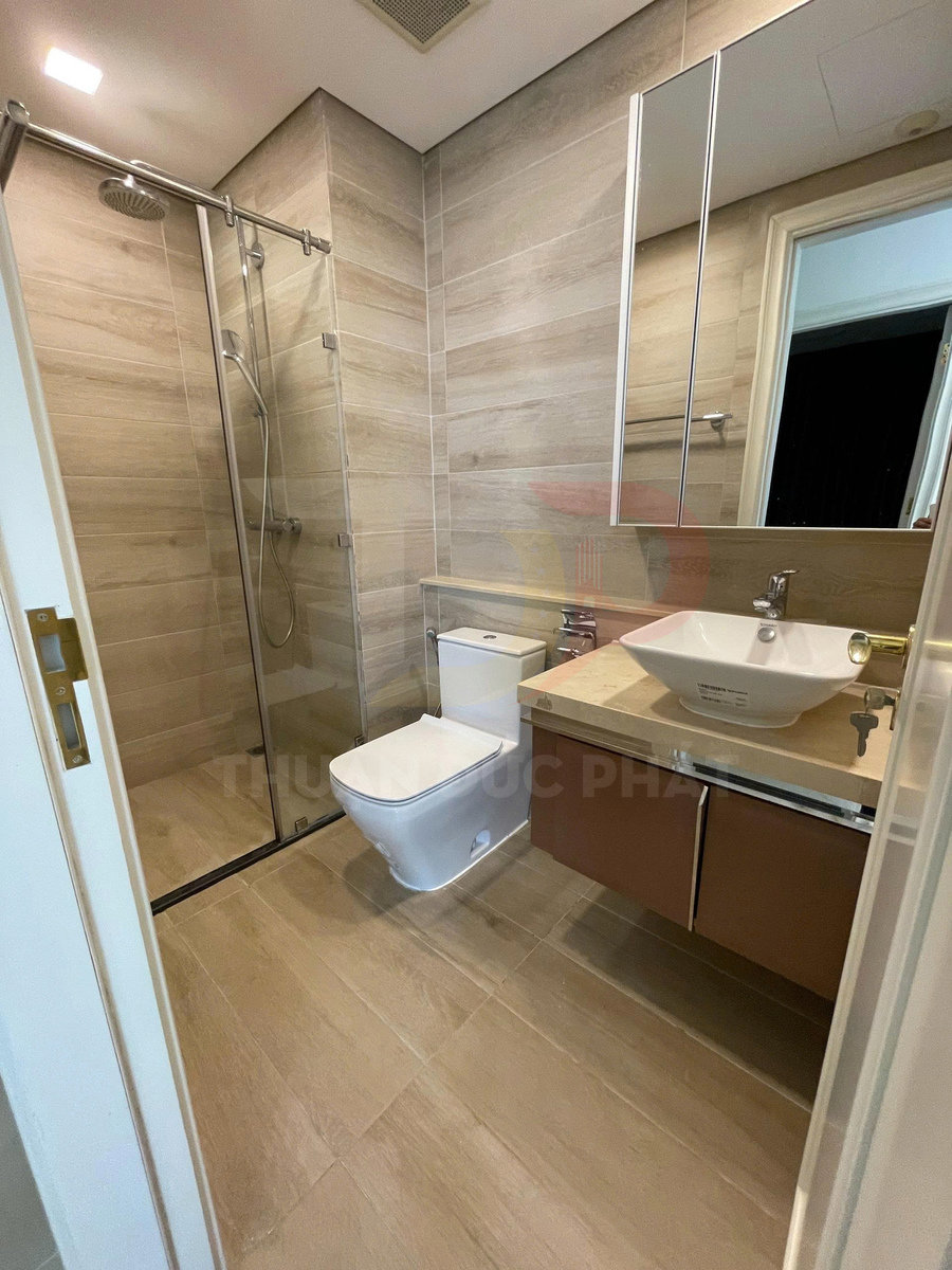 Phòng tắm hiện đại với buồng tắm kính, bồn cầu, lavabo đặt bàn và tủ gỗ dưới gương lớn