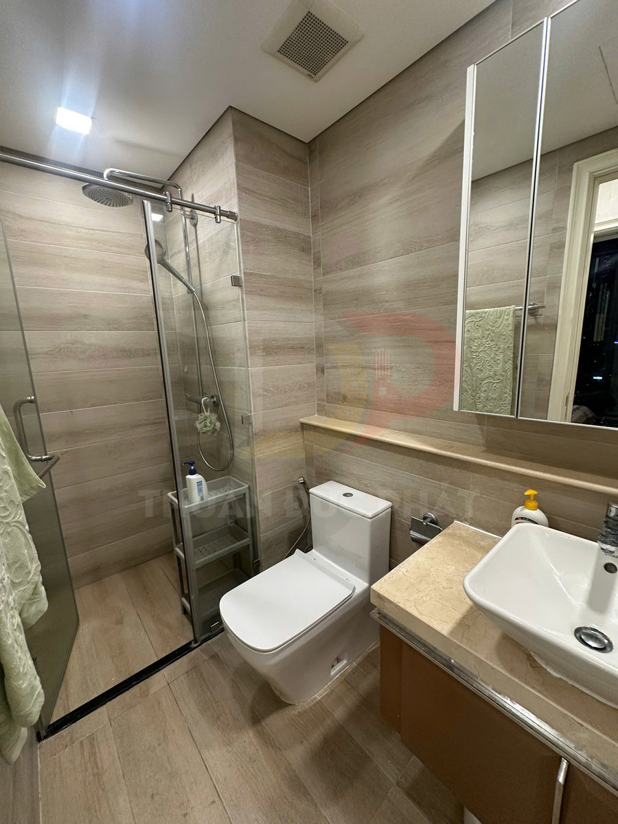 Phòng tắm hiện đại với bồn cầu, buồng tắm kính, chậu rửa vuông và tủ lavabo gỗ sáng màu