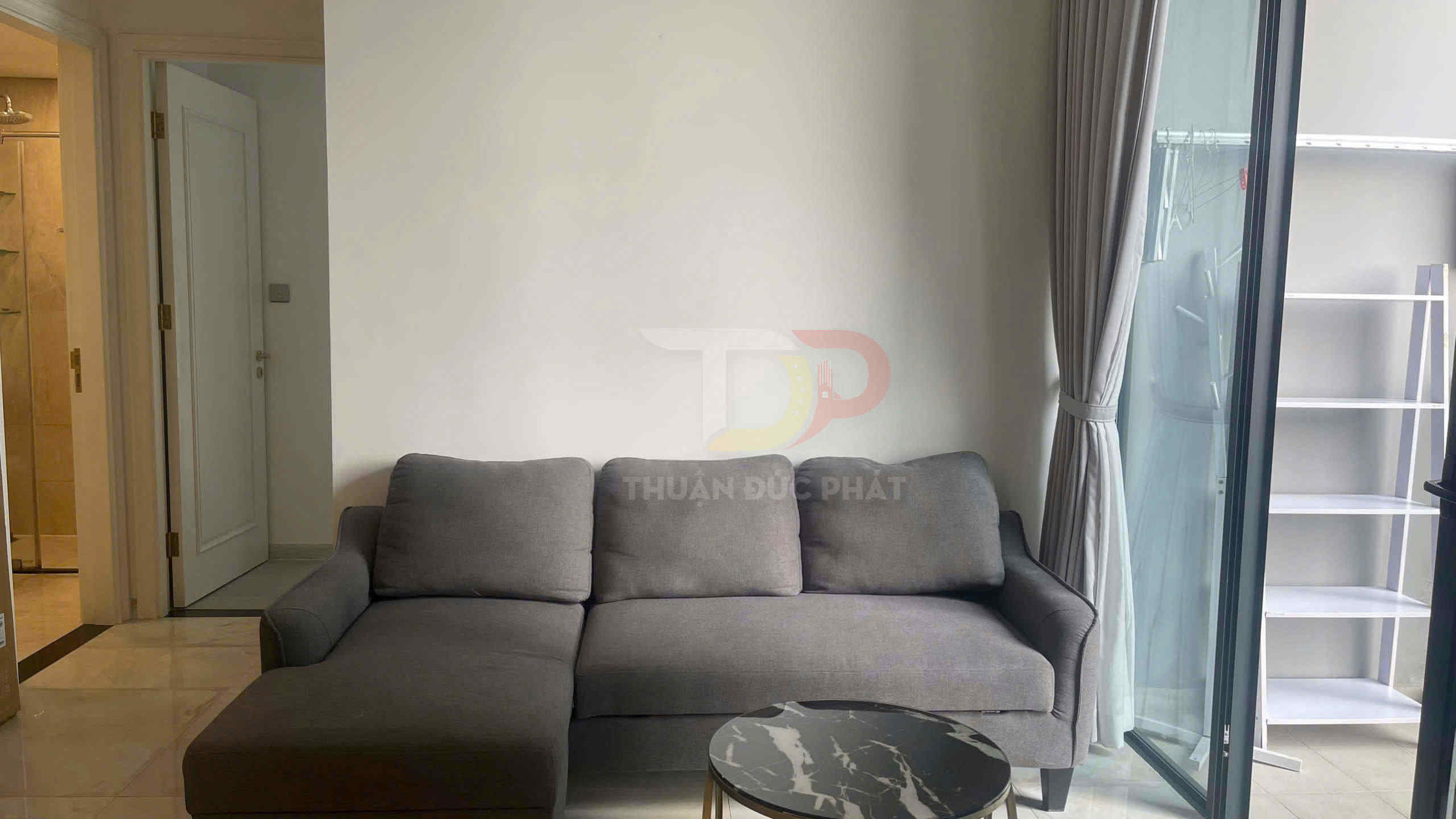 Sofa góc vải màu xám đặt cạnh cửa kính lớn trong phòng khách nhỏ hiện đại