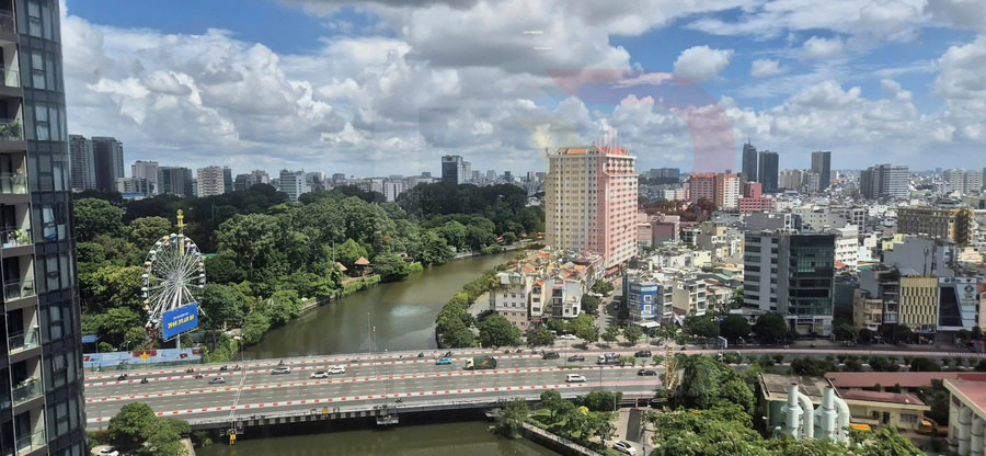 Toàn cảnh thành phố với sông, công viên cây xanh, vòng quay khổng lồ và các tòa nhà cao tầng dưới bầu trời nhiều mây