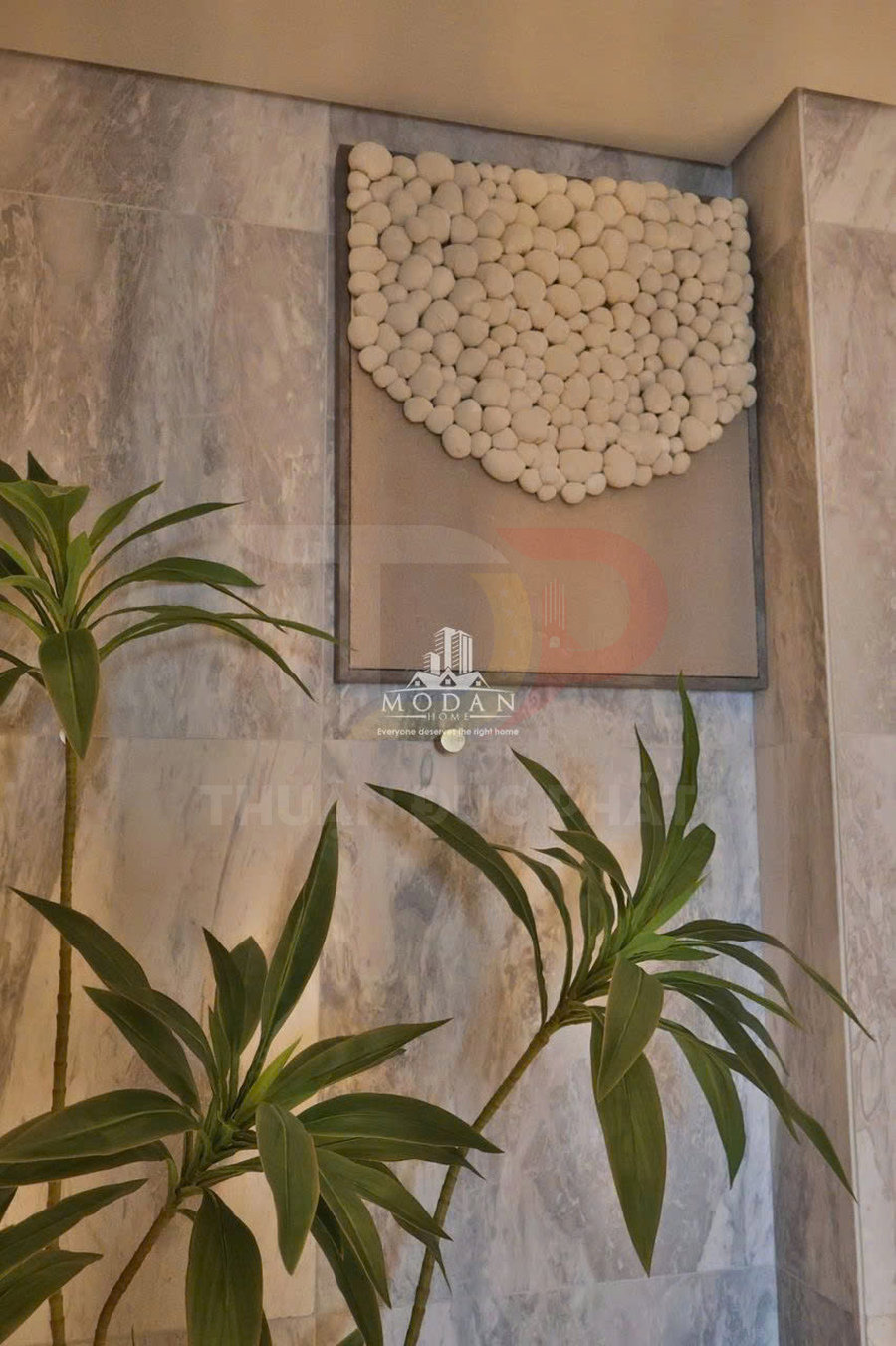 Tranh treo tường trang trí đá cuội trắng trên nền tường đá marble kèm cây xanh nội thất