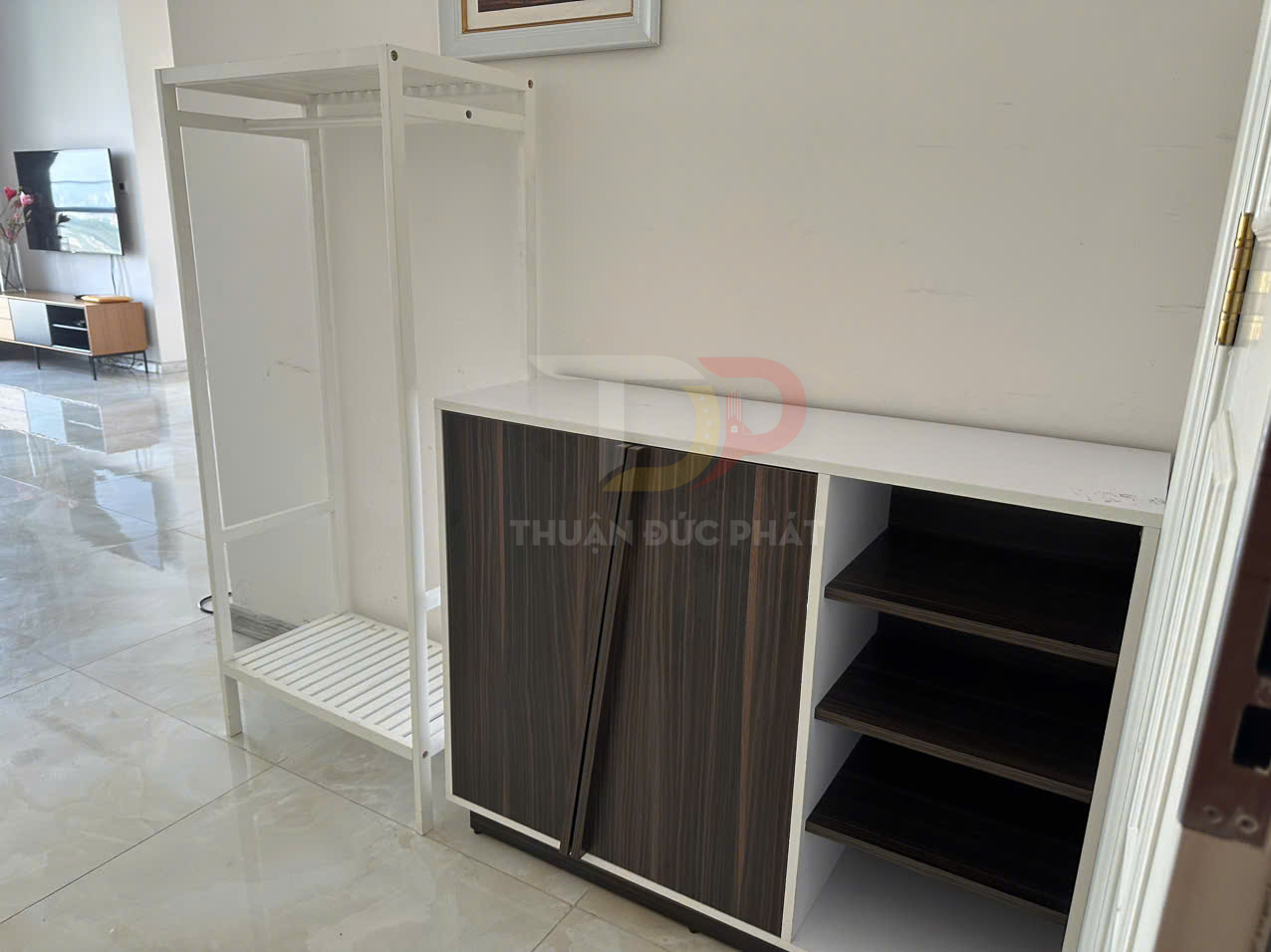 Tủ giày gỗ nhiều ngăn màu nâu trắng đặt cạnh kệ treo quần áo khung sắt trắng trong phòng khách hiện đại