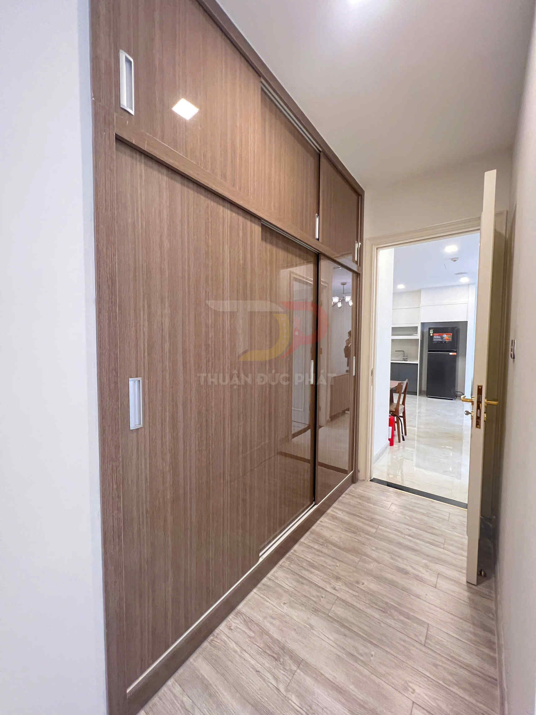 Tủ quần áo âm tường cửa lùa gỗ công nghiệp màu nâu trong hành lang căn hộ hiện đại