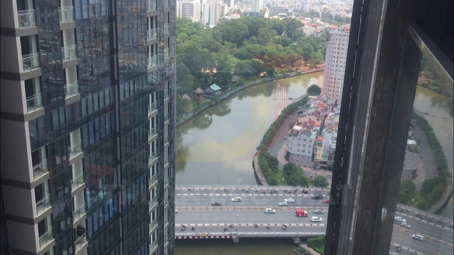 View từ căn hộ chung cư cao tầng nhìn xuống sông, công viên và đường cao tốc đông xe cộ