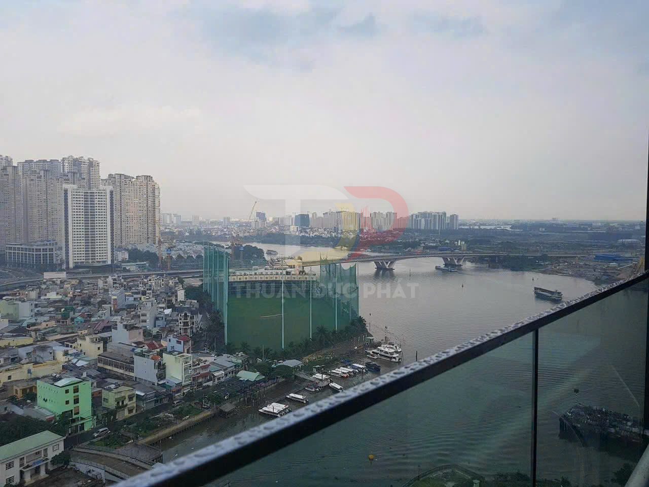View ban công kính cường lực nhìn ra sông và khu chung cư cao tầng trong thành phố