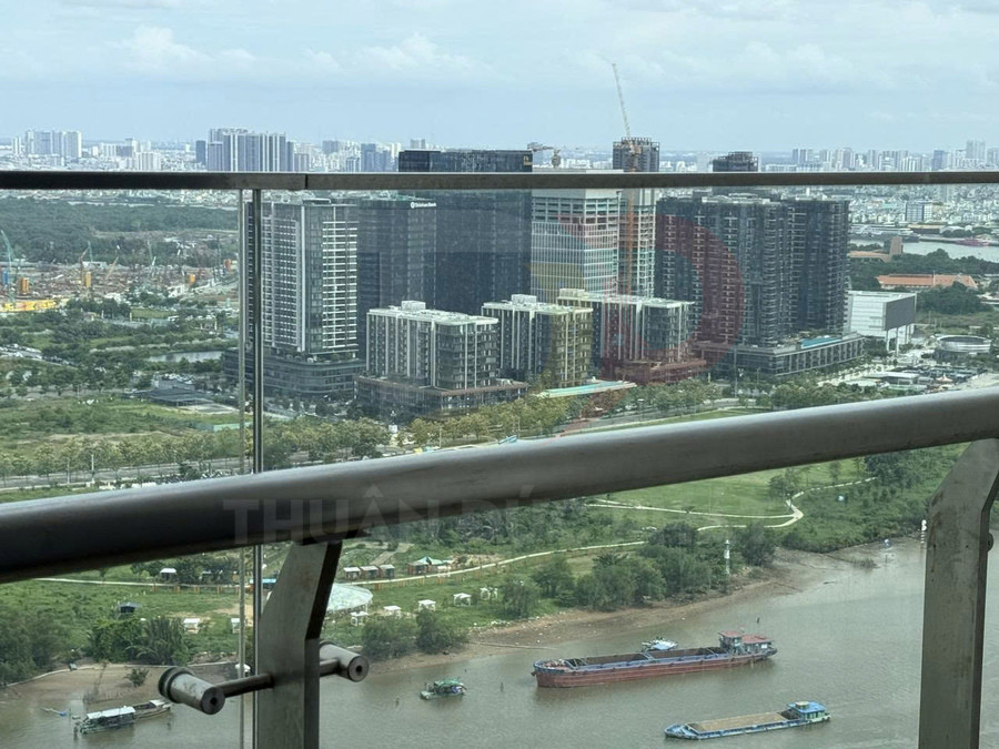 Ban công căn hộ nhìn ra khu chung cư cao tầng ven sông và công viên xanh trong thành phố