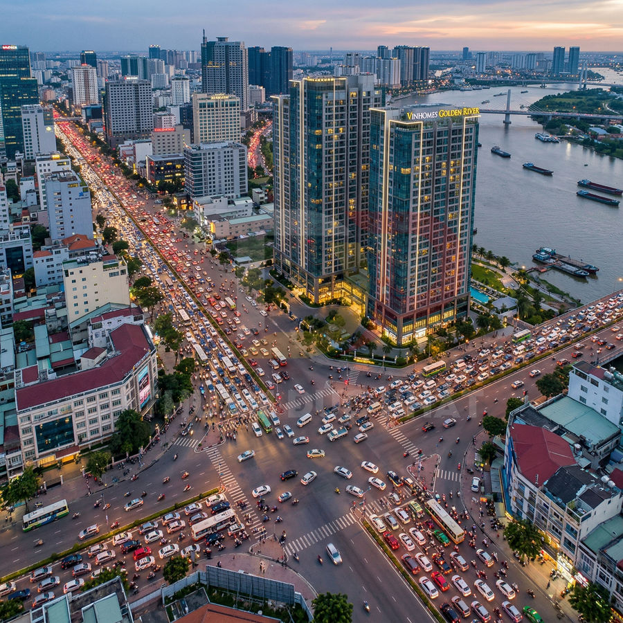 Tòa nhà Vinhomes Golden River bên sông với nút giao thông đông đúc lúc hoàng hôn