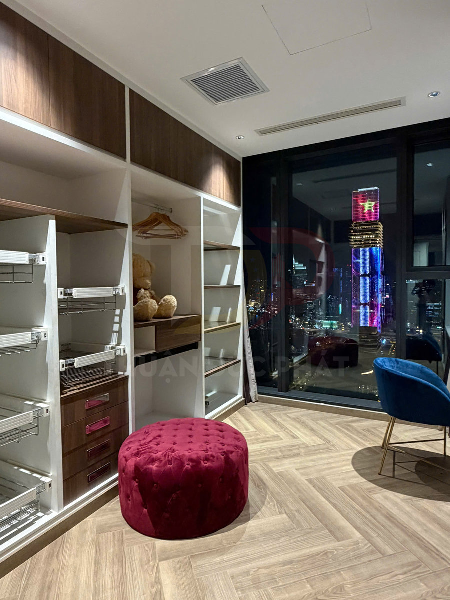 Tủ quần áo âm tường gỗ hiện đại với ghế đôn nhung đỏ trong phòng ngủ view thành phố ban đêm