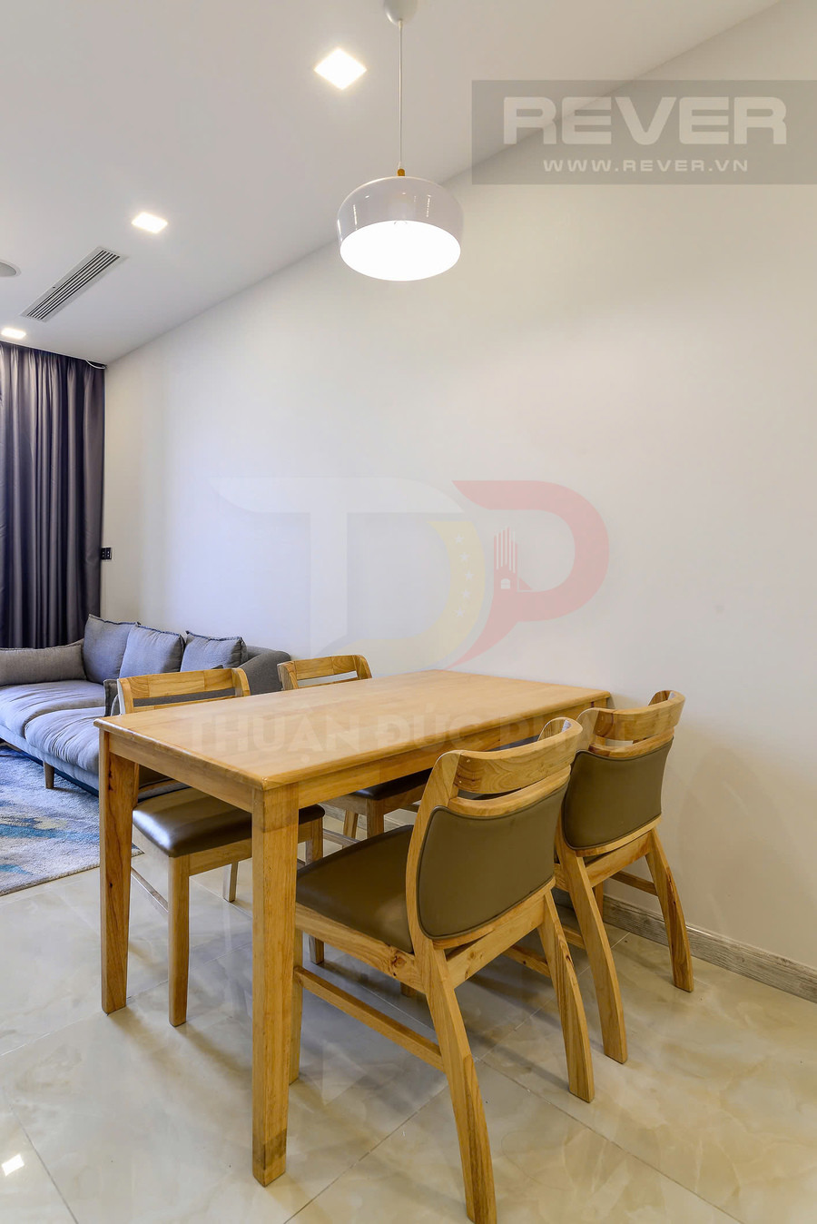 Bộ bàn ăn gỗ 4 ghế đệm da trong phòng khách căn hộ hiện đại có sofa xám